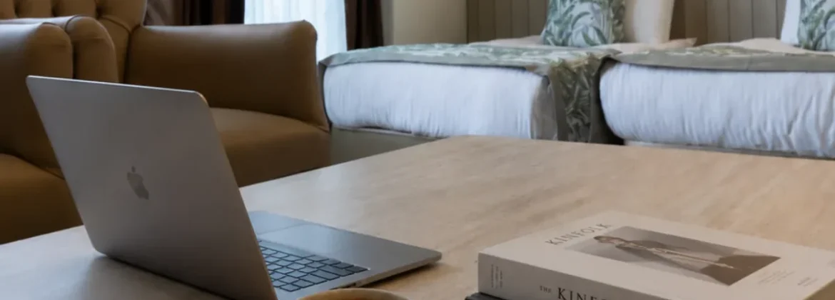 Otel odasında laptop ve kahve ile hazırlanan çalışma düzeni