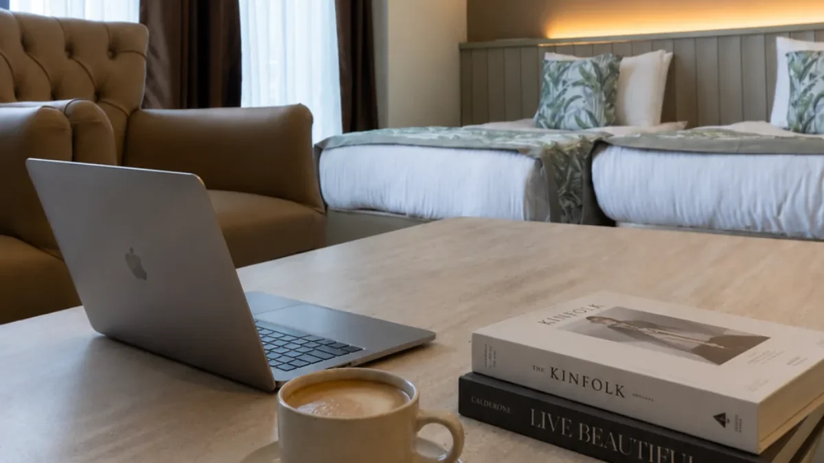 Otel odasında laptop ve kahve ile hazırlanan çalışma düzeni